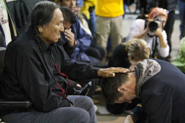 Leonard Crow Dog, a Lakota elder and highly-regarded activist, left, places his hand over Gen. Wesley Clark Jr.'s head during a forgiveness ceremony for veterans at the Four Prairie Knights Casino & Resort on the Standing Rock Sioux Reservation on Monday, Dec. 5, 2016.